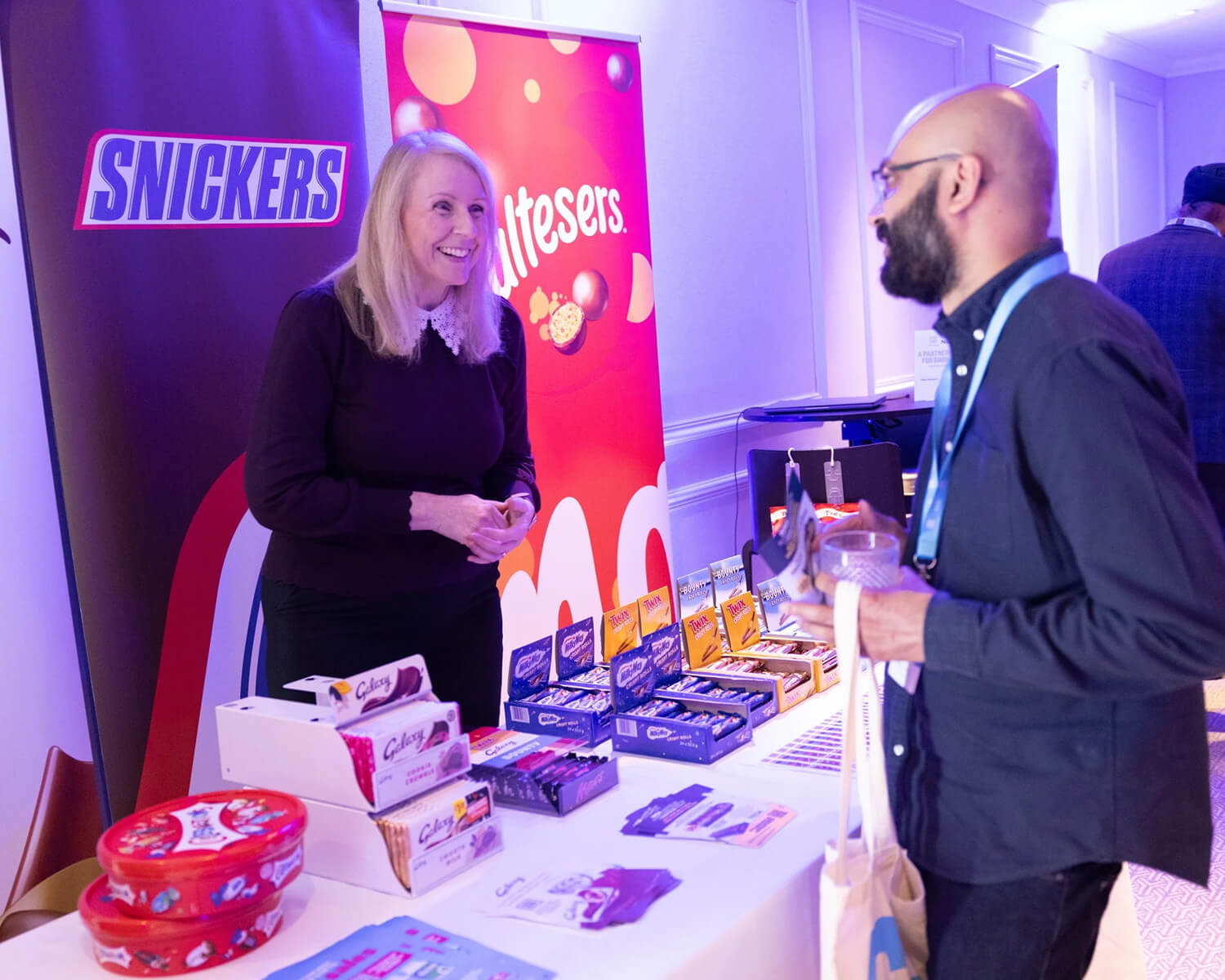 Exhibitor talking to attendees about their chocolate products