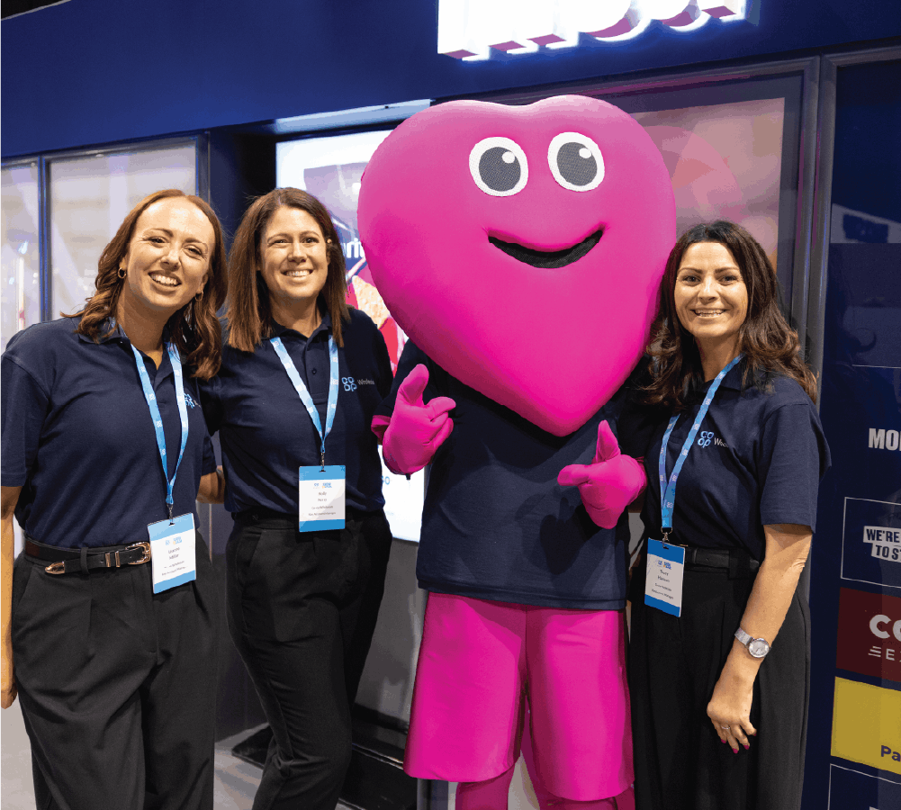 Exhibitors with love heart mascot smiling