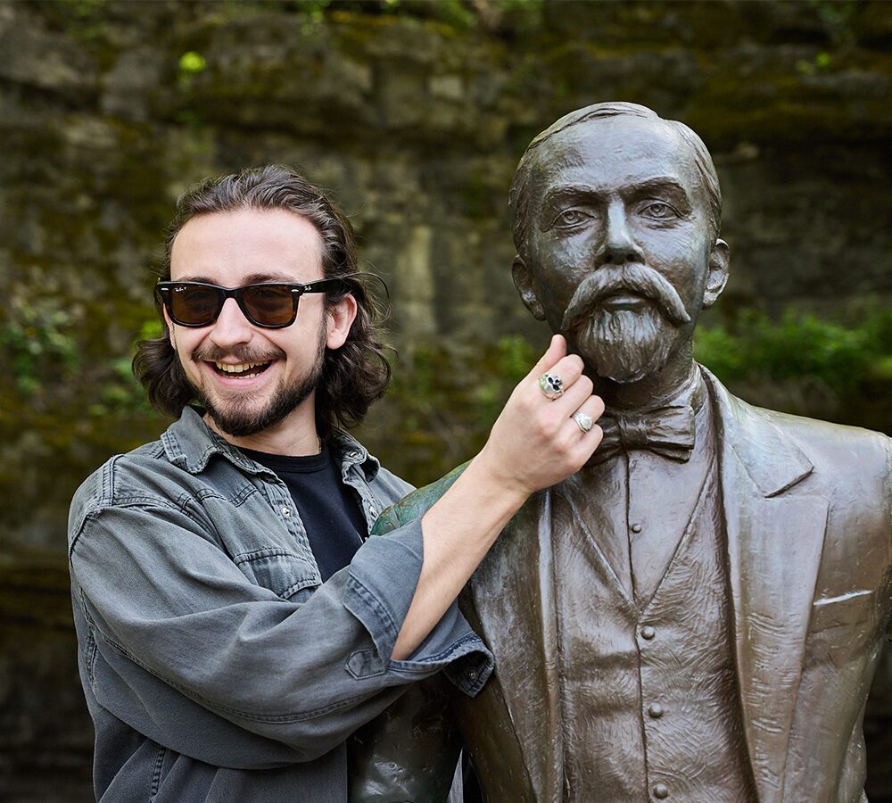 Smiling attendee posing with statue